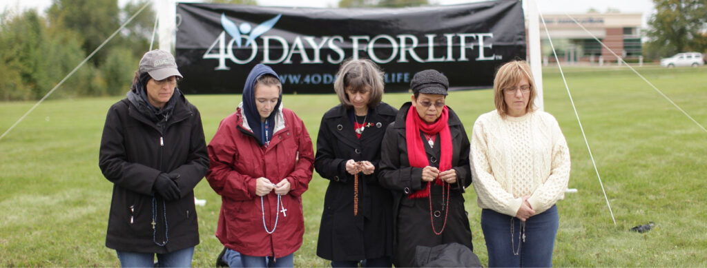 Photo of women praying in front of 40 days for life banner by 40 Days for Life.