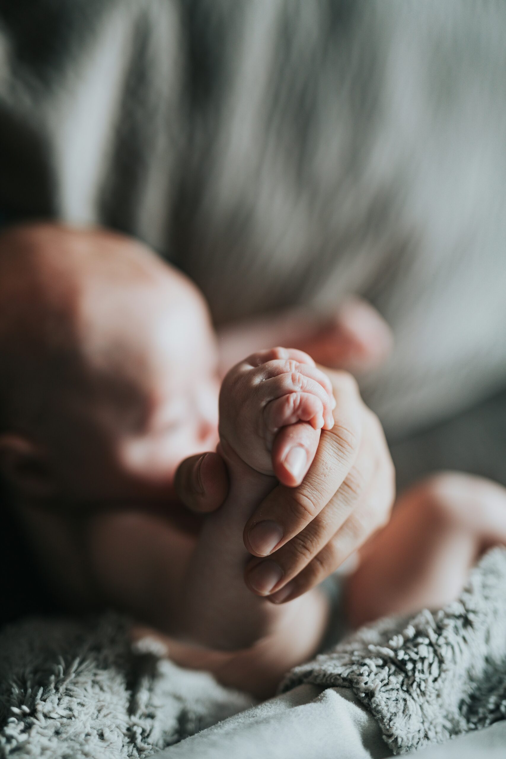 Photo of newborn holding mother's hand by Nathan Dumlao on Unsplash